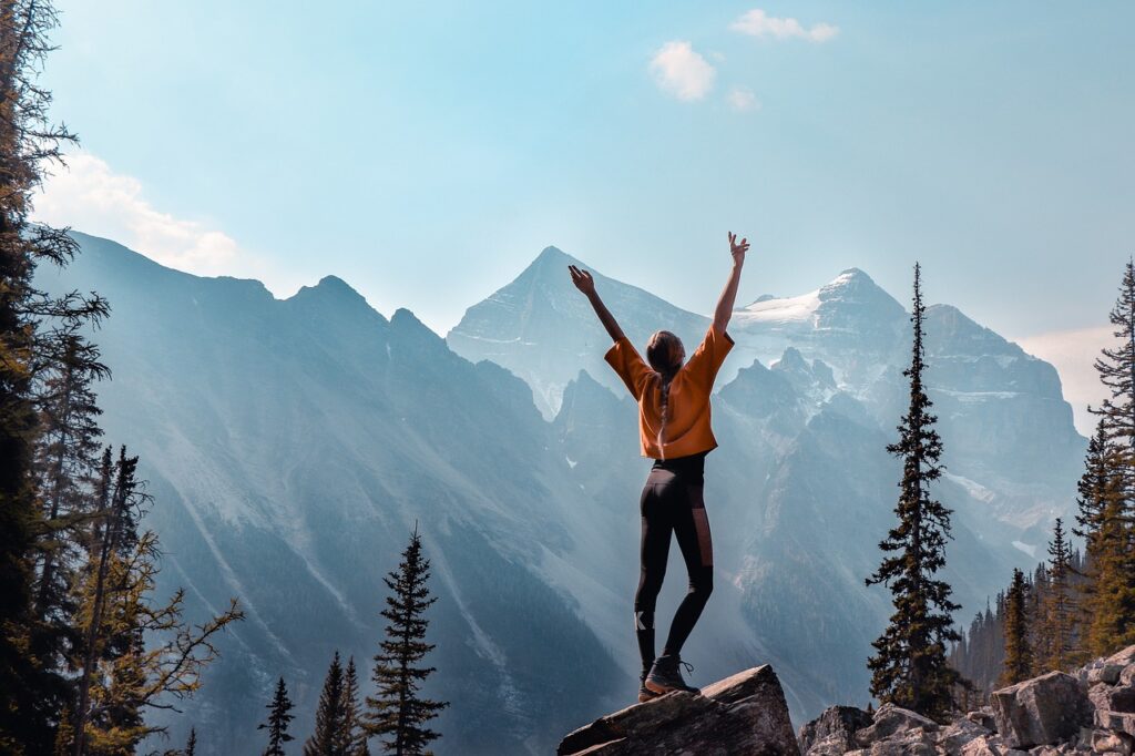 Frau streckt sich mit Blick auf die Berge aus